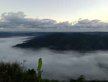 Cloud-filled valleys below the forested ridges of the Shillong plateau at dawn